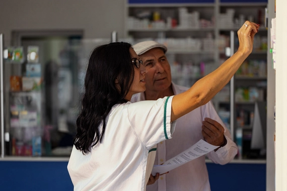 Pharmacy technician filling prescription at counter